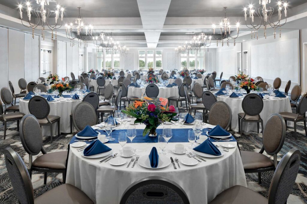 indoor venue with some windows and round tables with cushioned chairs